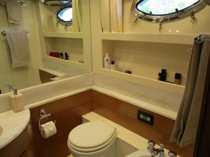 Mr Chic Yacht Photos Pics Luxurious bathroom in a 2001 Riva 84 Cantata yacht, featuring elegant fixtures and porthole window.