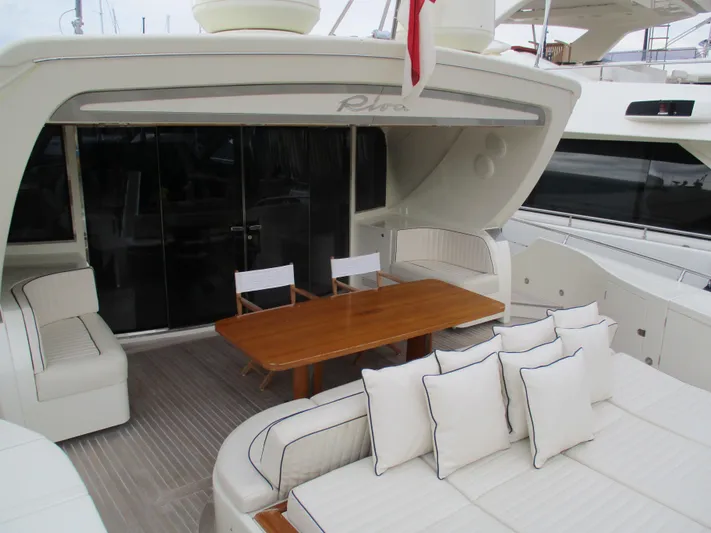 Mr Chic Yacht Photos Pics Luxurious 2001 Riva 84 Cantata yacht deck with elegant seating and wooden table.