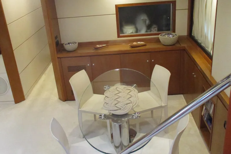Mr Chic Yacht Photos Pics Interior of 2001 Riva 84 Cantata yacht with modern dining area and glass table.