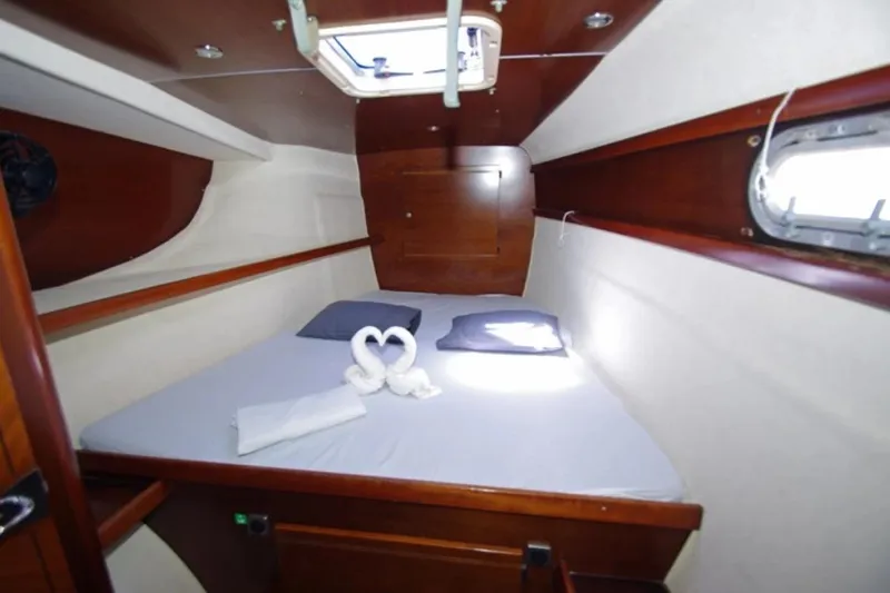  Yacht Photos Pics Cabin interior of 2004 Fountaine Pajot Bahia 46 catamaran with cozy bed and porthole.