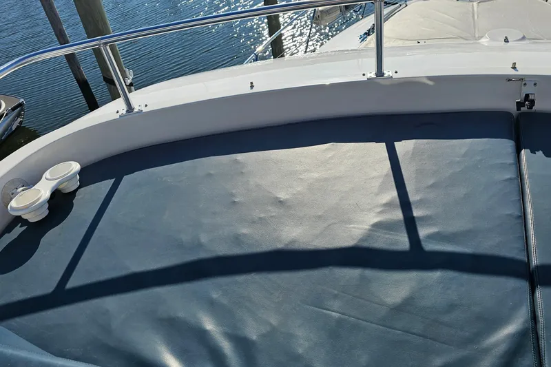 Dream Team Xiii Yacht Photos Pics 2005 Neptunus 56 Flybridge yacht with cushioned seating and railing, docked by the water.