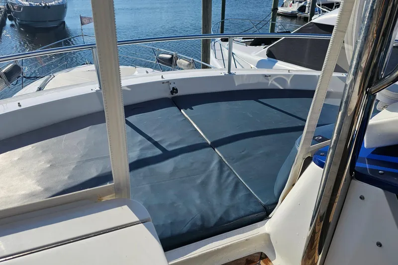 Dream Team Xiii Yacht Photos Pics 2005 Neptunus 56 Flybridge yacht deck with blue sun pad, docked at marina.