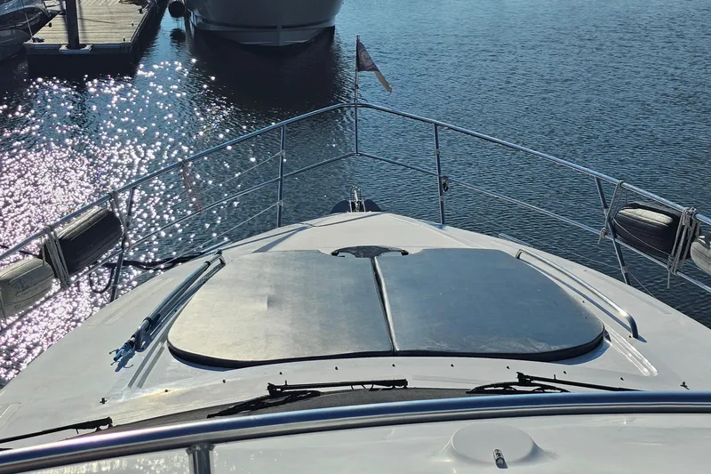 Dream Team Xiii Yacht Photos Pics Bow view of 2005 Neptunus 56 Flybridge yacht docked on sparkling water.