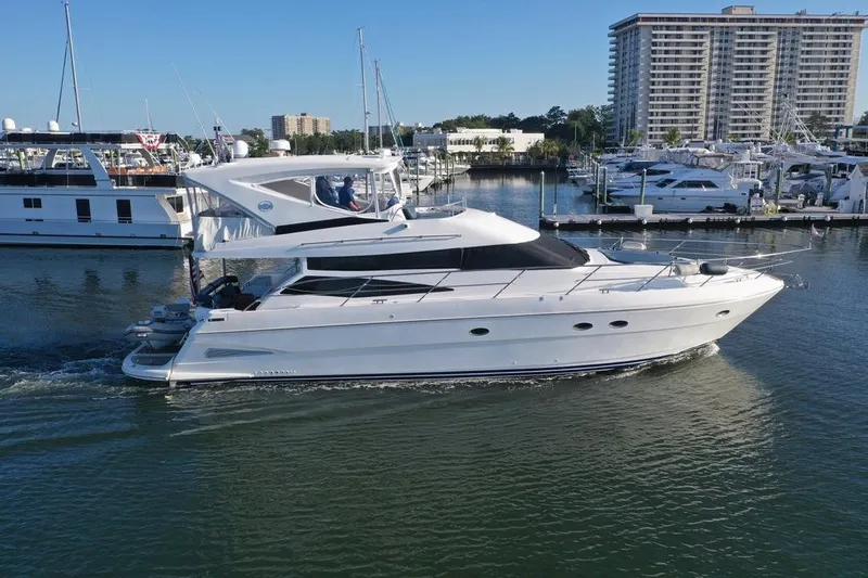 Dream Team Xiii Yacht Photos Pics 2005 Neptunus 56 Flybridge yacht cruising in a marina with modern buildings in the background.