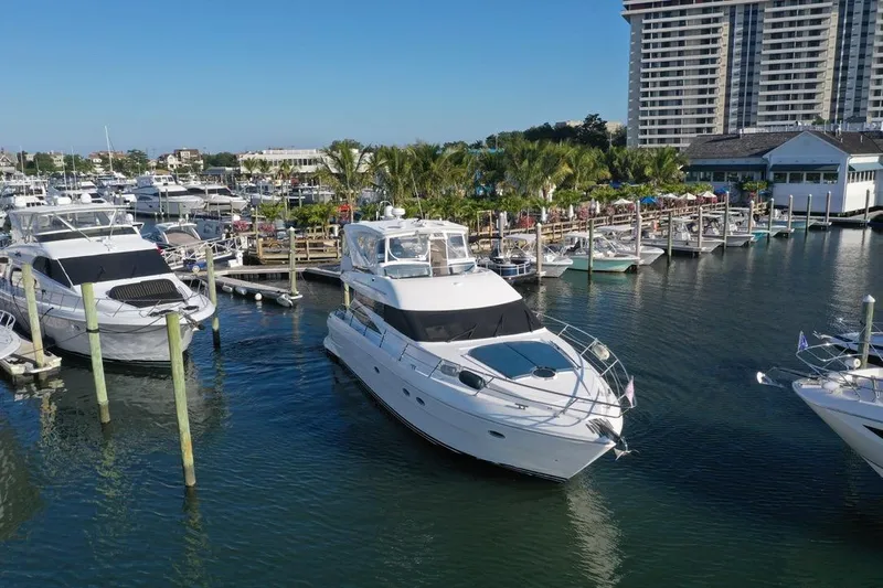 Dream Team Xiii Yacht Photos Pics 2005 Neptunus 56 Flybridge yacht docked at a marina with surrounding boats.