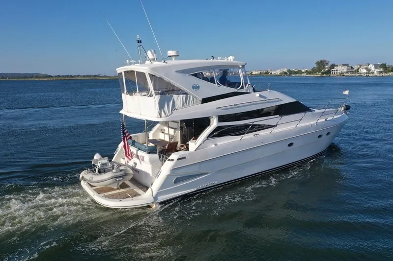 Dream Team Xiii Yacht Photos Pics 2005 Neptunus 56 Flybridge yacht cruising on a serene waterway.