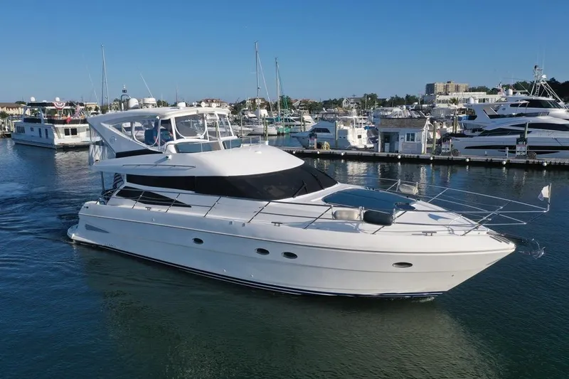 Dream Team Xiii Yacht Photos Pics 2005 Neptunus 56 Flybridge yacht cruising in a marina, surrounded by other boats.