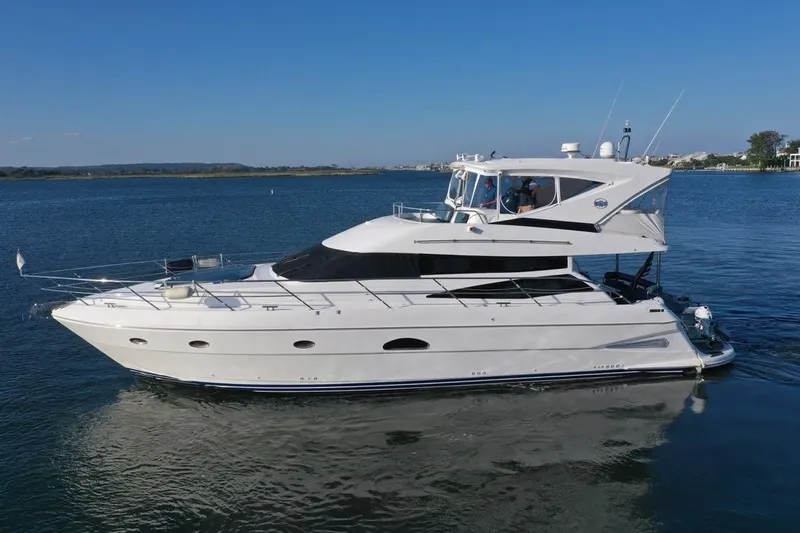 Dream Team Xiii Yacht Photos Pics 2005 Neptunus 56 Flybridge yacht cruising on calm waters under clear blue skies.