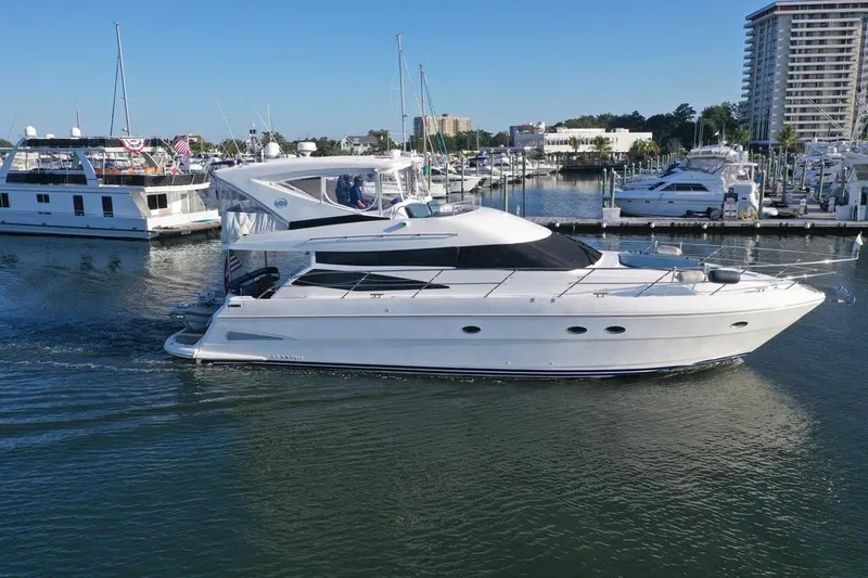 Dream Team Xiii Yacht Photos Pics 2005 Neptunus 56 Flybridge yacht cruising in a marina with nearby boats.