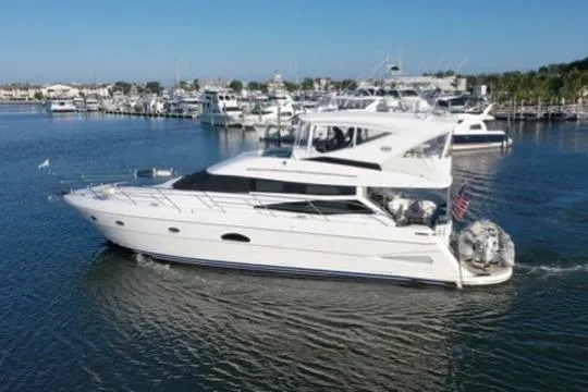 Dream Team Xiii Yacht Photos Pics 2005 Neptunus 56 Flybridge yacht cruising in a marina, surrounded by other boats.