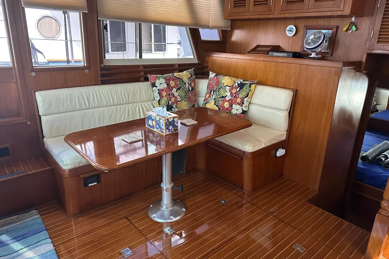 Off Ramp Yacht Photos Pics Luxurious 2002 Novatec Sundeck yacht interior with wooden dining area and floral cushions.