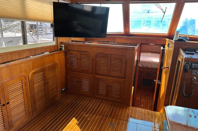 Off Ramp Yacht Photos Pics 2002 Novatec Sundeck interior with wooden cabinetry and mounted TV.