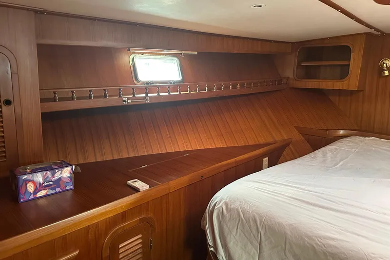 Off Ramp Yacht Photos Pics Cozy wooden cabin interior of 2002 Novatec Sundeck yacht with bed and porthole.