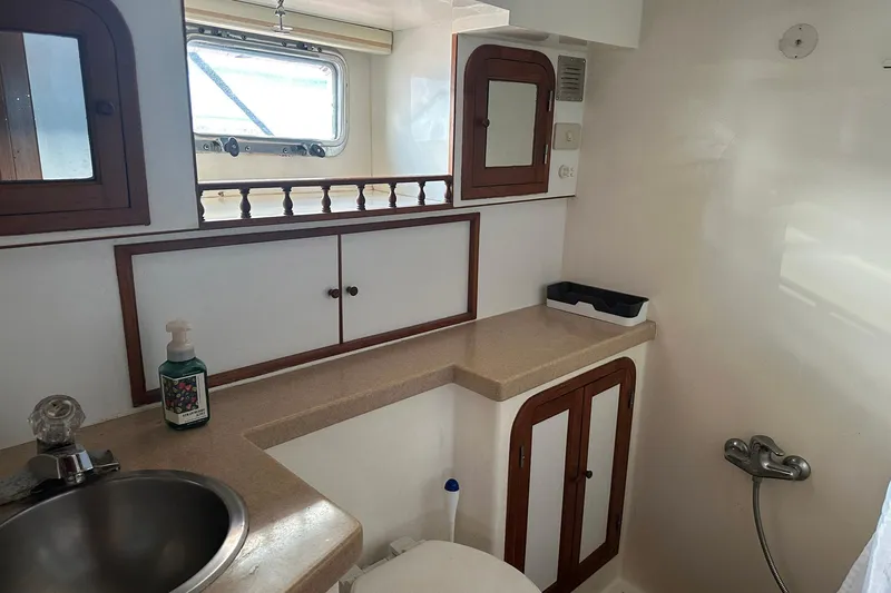 Off Ramp Yacht Photos Pics 2002 Novatec Sundeck yacht bathroom with sink, cabinets, and window.