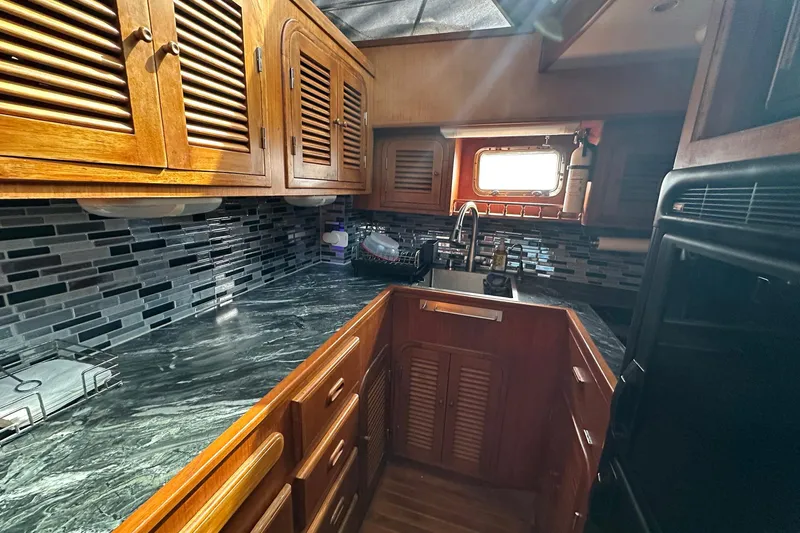 Off Ramp Yacht Photos Pics Luxurious 2002 Novatec Sundeck yacht kitchen with wooden cabinets and modern backsplash.