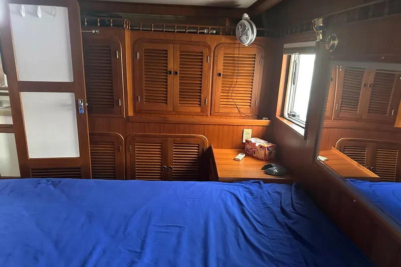 Off Ramp Yacht Photos Pics Cozy cabin interior of 2002 Novatec Sundeck yacht with wooden cabinets and blue bedding.