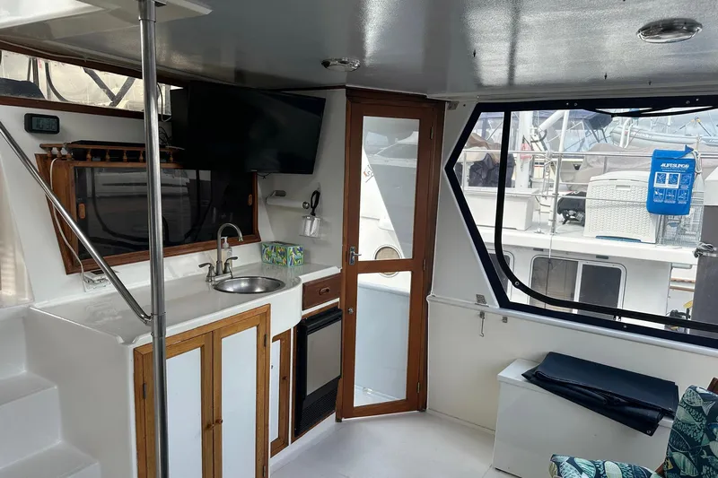 Off Ramp Yacht Photos Pics Interior of 2002 Novatec Sundeck yacht with kitchenette, TV, and outdoor view.