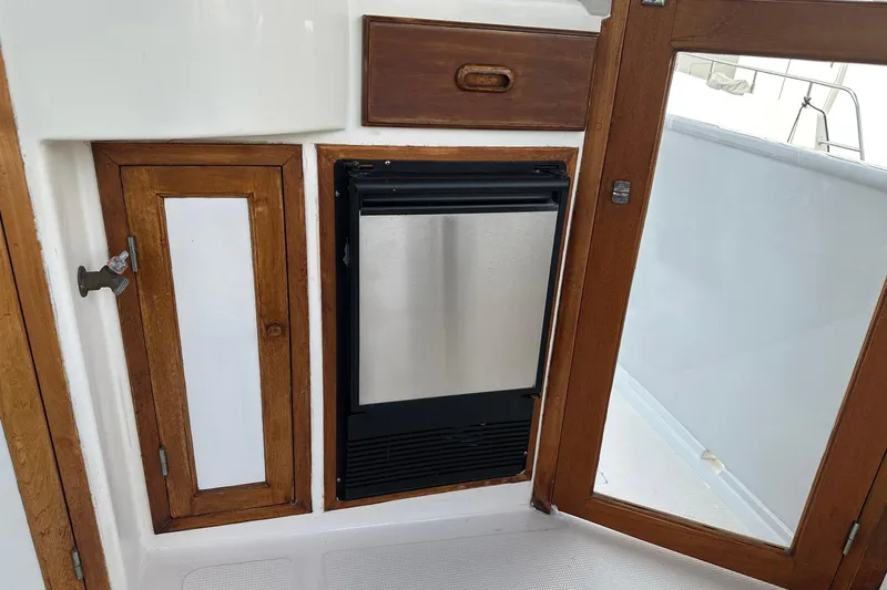 Off Ramp Yacht Photos Pics 2002 Novatec Sundeck interior with wooden cabinetry and stainless steel appliance.