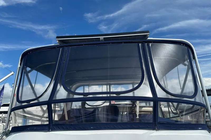 Off Ramp Yacht Photos Pics 2002 Novatec Sundeck boat with clear enclosure under a blue sky.