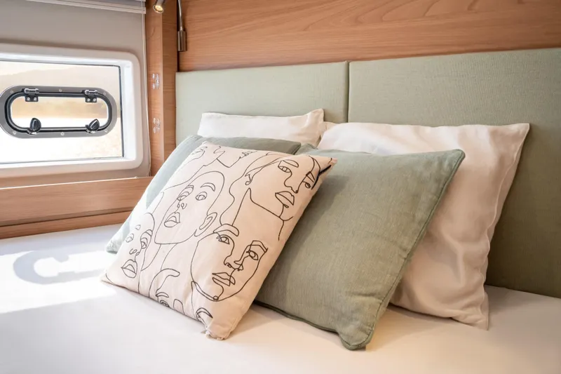  Yacht Photos Pics Cozy Bali 4.6 2026 interior with artistic pillows and soft bedding.