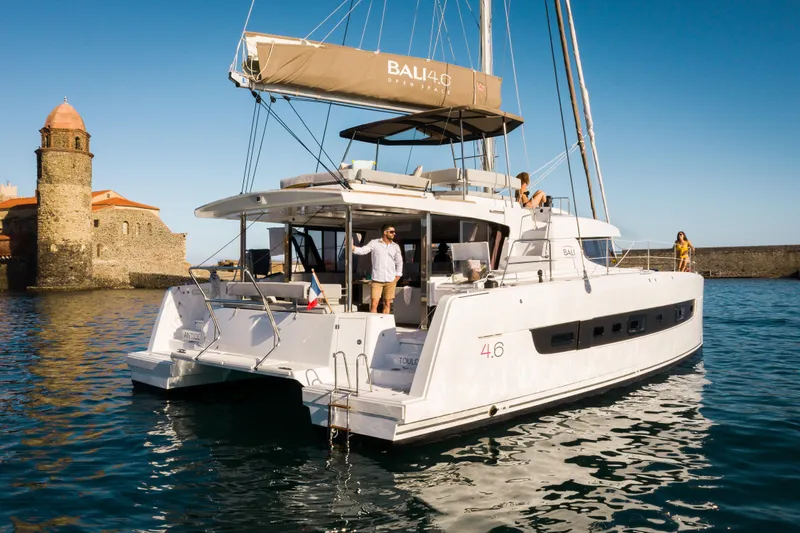  Yacht Photos Pics Luxurious 2026 Bali 4.6 catamaran sailing near historic coastal architecture.