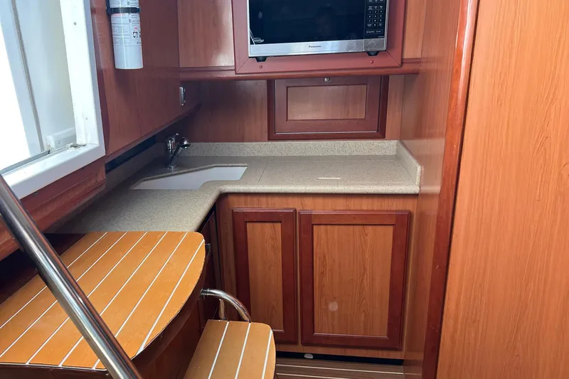 Reel Obsession Yacht Photos Pics 2007 Luhrs 41 Hardtop yacht interior kitchen with wood cabinetry and microwave.