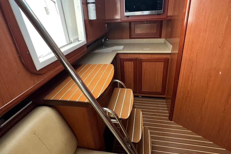 Reel Obsession Yacht Photos Pics 2007 Luhrs 41 Hardtop interior with wooden cabinetry, compact kitchen, and seating area.