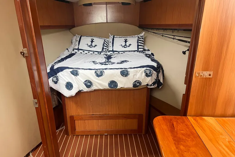 Reel Obsession Yacht Photos Pics 2007 Luhrs 41 Hardtop cabin with nautical-themed bedding and wooden interior.
