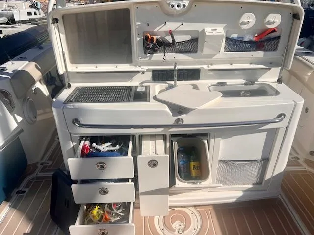 Sea SeÑor Yacht Photos Pics 2017 Boston Whaler 370 Outrage boat interior with open storage compartments and fishing gear.