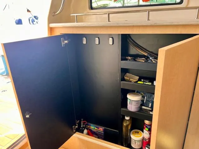 Sea SeÑor Yacht Photos Pics Open cabinet on 2017 Boston Whaler 370 Outrage, showing shelves with various items.