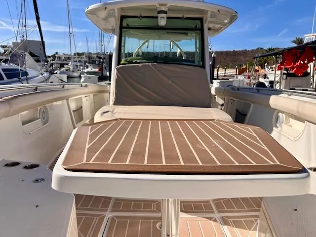Sea SeÑor Yacht Photos Pics 2017 Boston Whaler 370 Outrage boat interior with table and seating in marina.