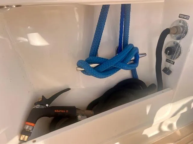 Sea SeÑor Yacht Photos Pics Storage compartment on a 2017 Boston Whaler 370 Outrage with hose and blue rope.