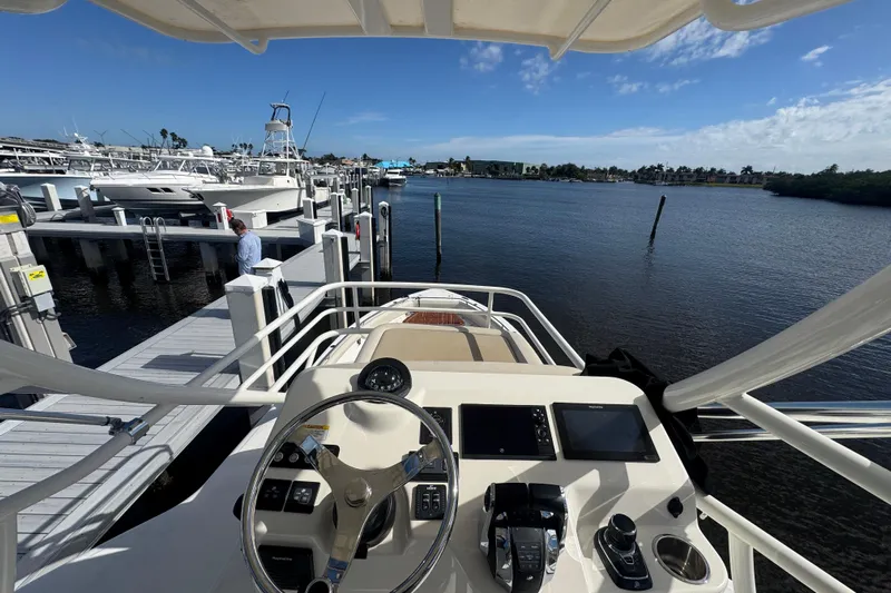  Yacht Photos Pics Boston Whaler 420 Outrage 2020 at marina, view from helm, clear sky.