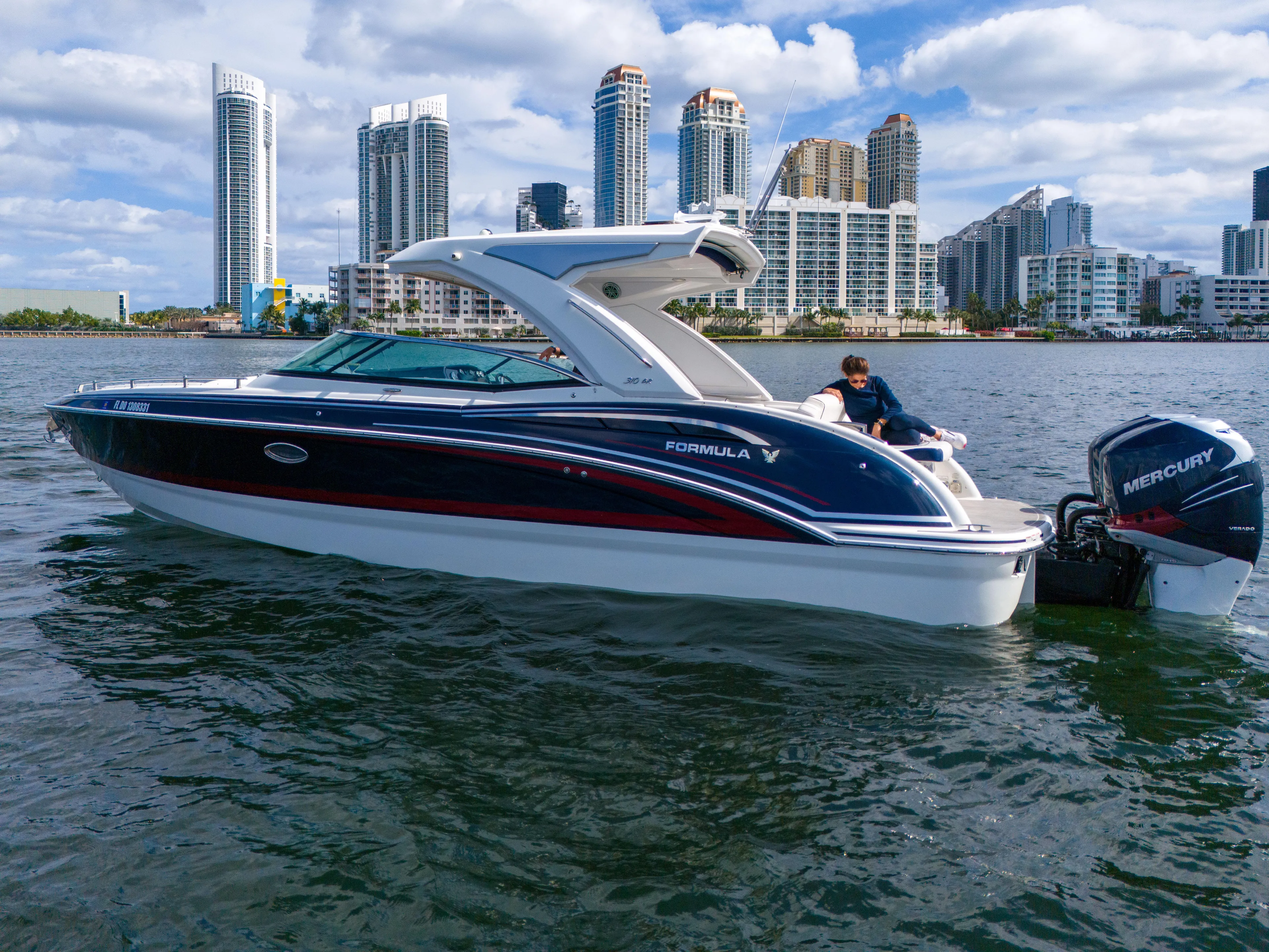 Without A Kaire Yacht Photos Pics 2020 Formula 310 Bowrider boat on water with city skyline in background.