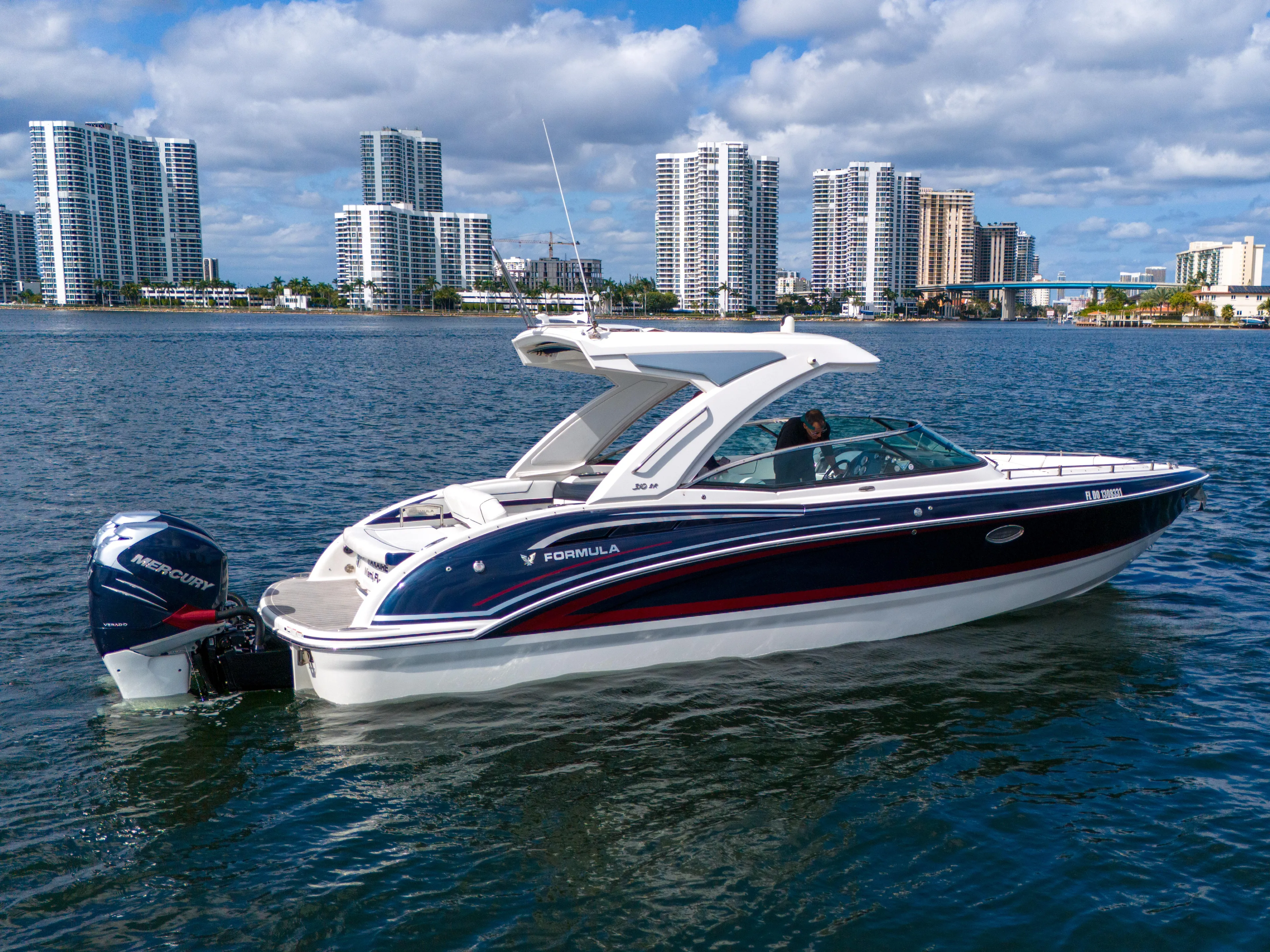 Without A Kaire Yacht Photos Pics 2020 Formula 310 Bowrider boat on water with city skyline in background.