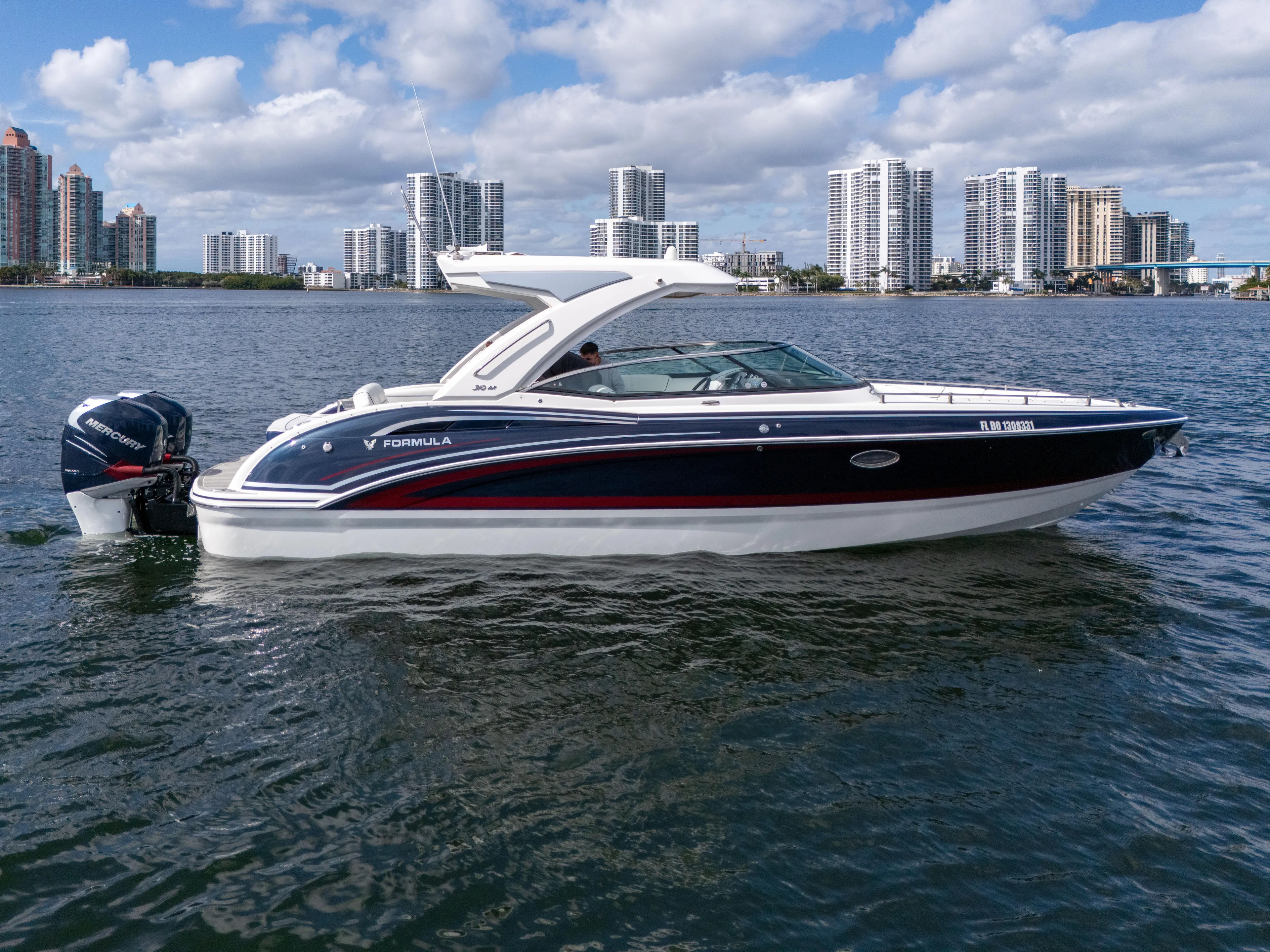 Without A Kaire Yacht Photos Pics 2020 Formula 310 Bowrider boat on water with city skyline background.