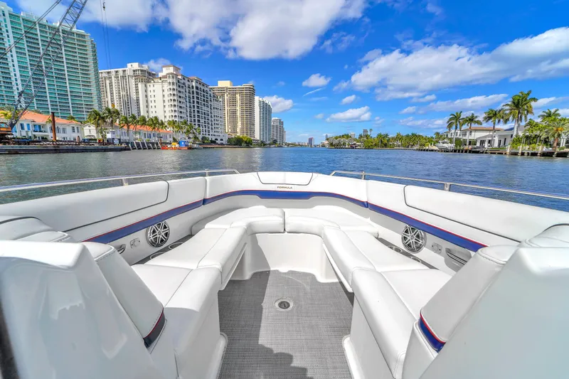 Without A Kaire Yacht Photos Pics 2020 Formula 310 Bowrider on a scenic waterfront with city skyline and palm trees.