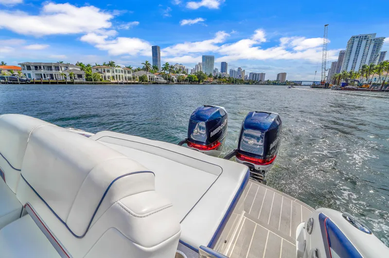 Without A Kaire Yacht Photos Pics 2020 Formula 310 Bowrider on water, city skyline in background, dual outboard engines.