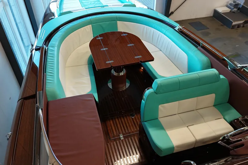 Anniversario No. 7 Of 18 Yacht Photos Pics 2024 Riva Anniversario boat interior with turquoise and white seating, wooden table, and elegant design.