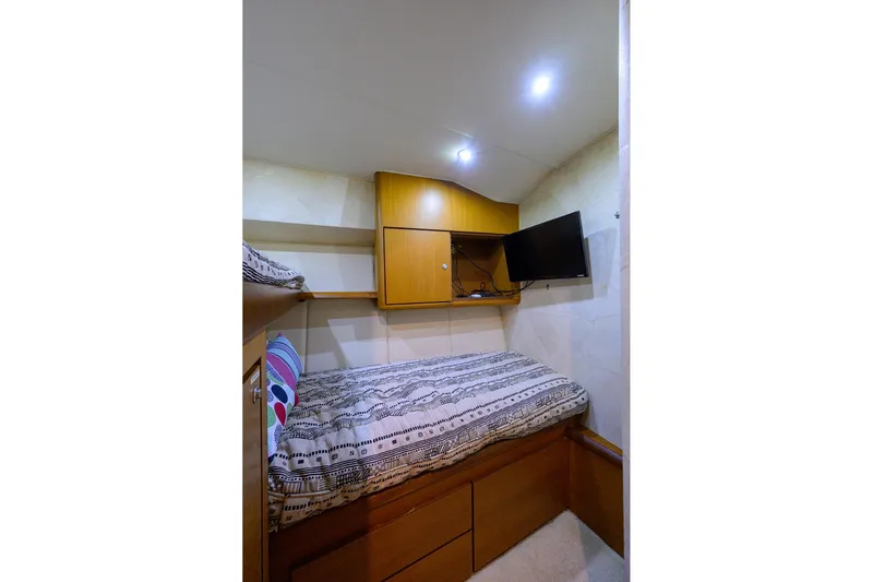 Members Only Yacht Photos Pics Cozy cabin interior of 2001 Ocean Yachts Super Sport with bed, TV, and storage.