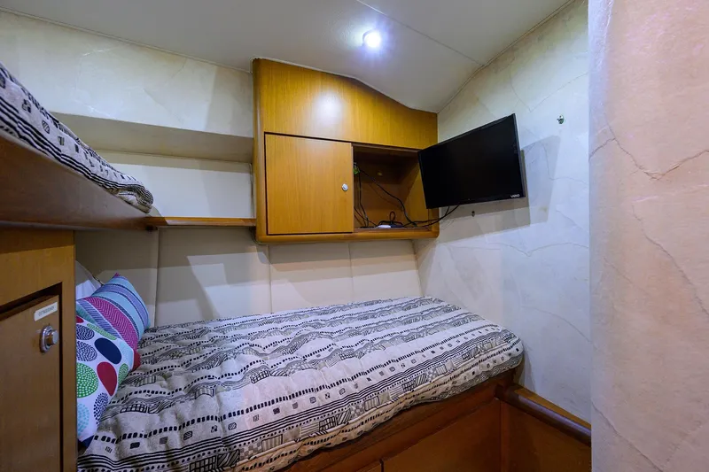Members Only Yacht Photos Pics 2001 Ocean Yachts Super Sport cabin with bed, TV, and wooden storage.