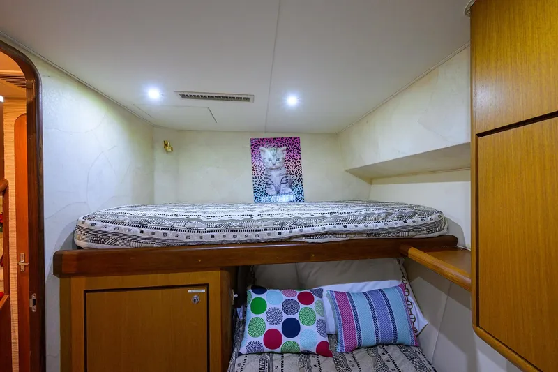 Members Only Yacht Photos Pics Cozy cabin interior of 2001 Ocean Yachts Super Sport with bunk beds and colorful pillows.