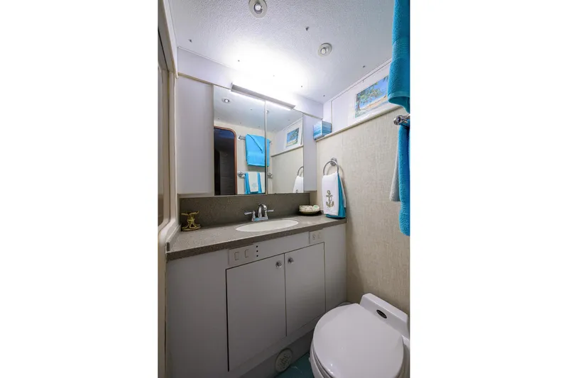 Members Only Yacht Photos Pics Bathroom interior of 2001 Ocean Yachts Super Sport, featuring sink, mirror, and toilet.