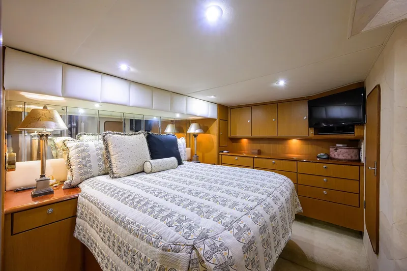 Members Only Yacht Photos Pics Luxurious bedroom interior of 2001 Ocean Yachts Super Sport with elegant bedding and wooden cabinetry.