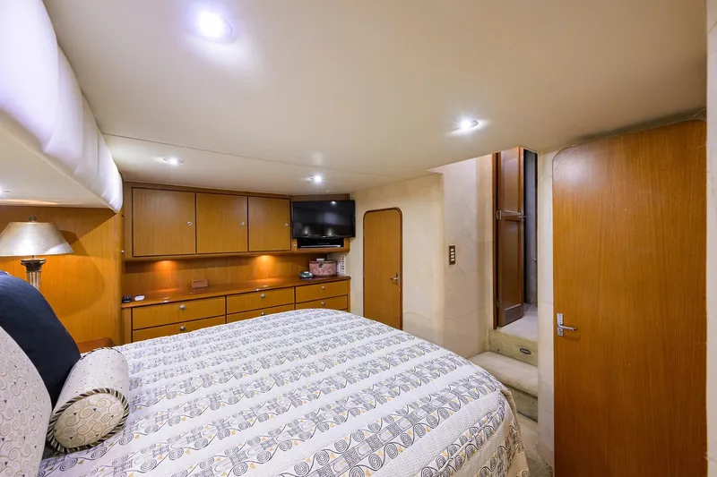 Members Only Yacht Photos Pics Luxurious bedroom interior of 2001 Ocean Yachts Super Sport with wood cabinetry and modern lighting.