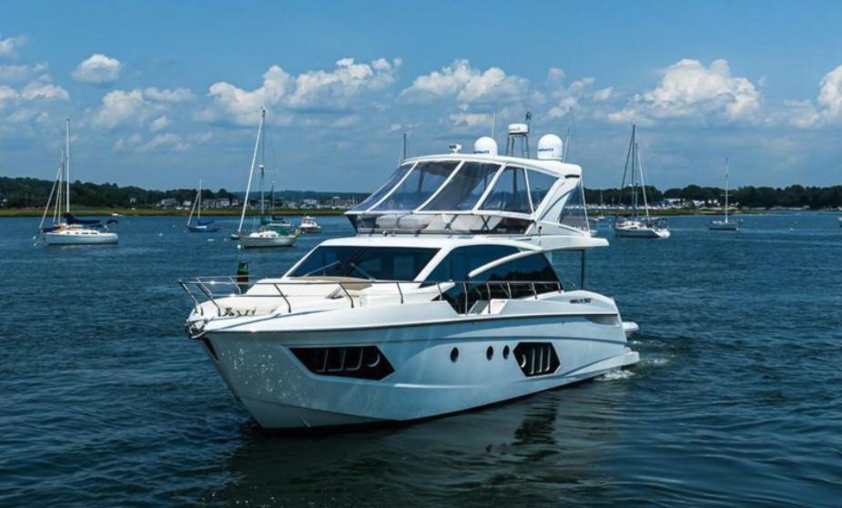 2017 Absolute 50 Fly yacht cruising on a sunny day with sailboats in the background.