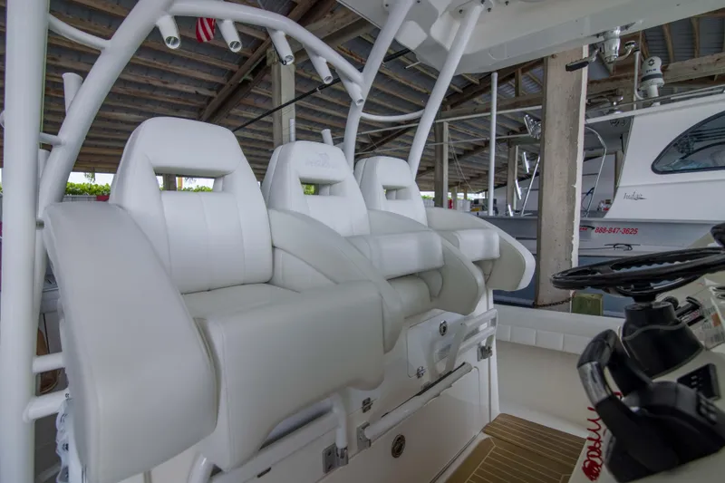 Miss Megan Yacht Photos Pics 2021 Regulator 41 boat interior with white cushioned seats and steering wheel.