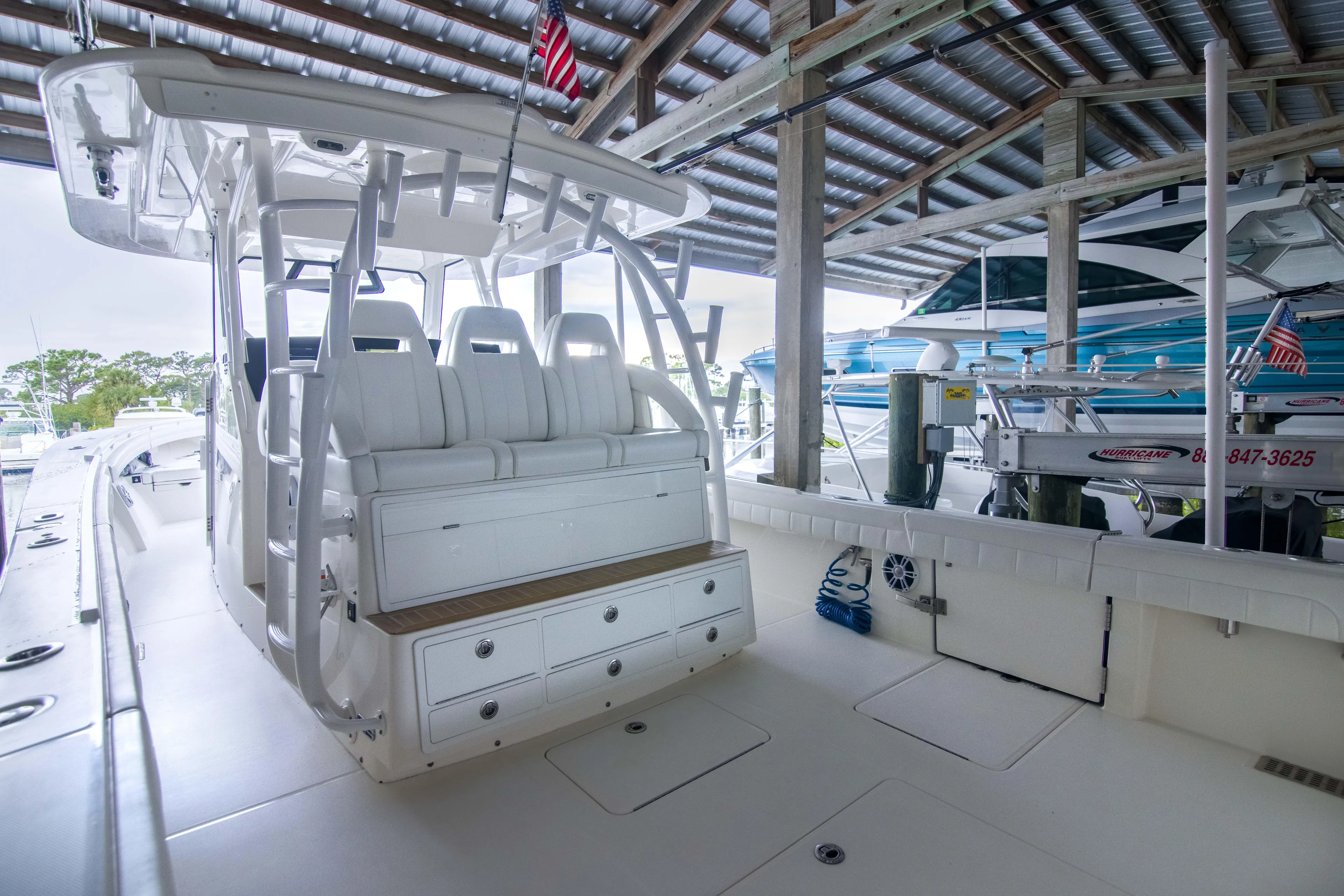 Miss Megan Yacht Photos Pics 2021 Regulator 41 boat interior with white seating and storage, docked under a covered area.