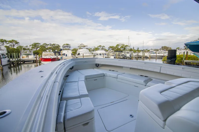 Miss Megan Yacht Photos Pics 2021 Regulator 41 boat with spacious seating, docked at a marina under a partly cloudy sky.