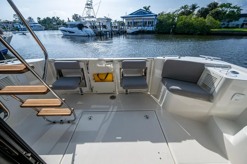 Ashokan Yacht Photos Pics 2022 Beneteau Swift Trawler 35 cockpit with seating, docked by waterfront homes.
